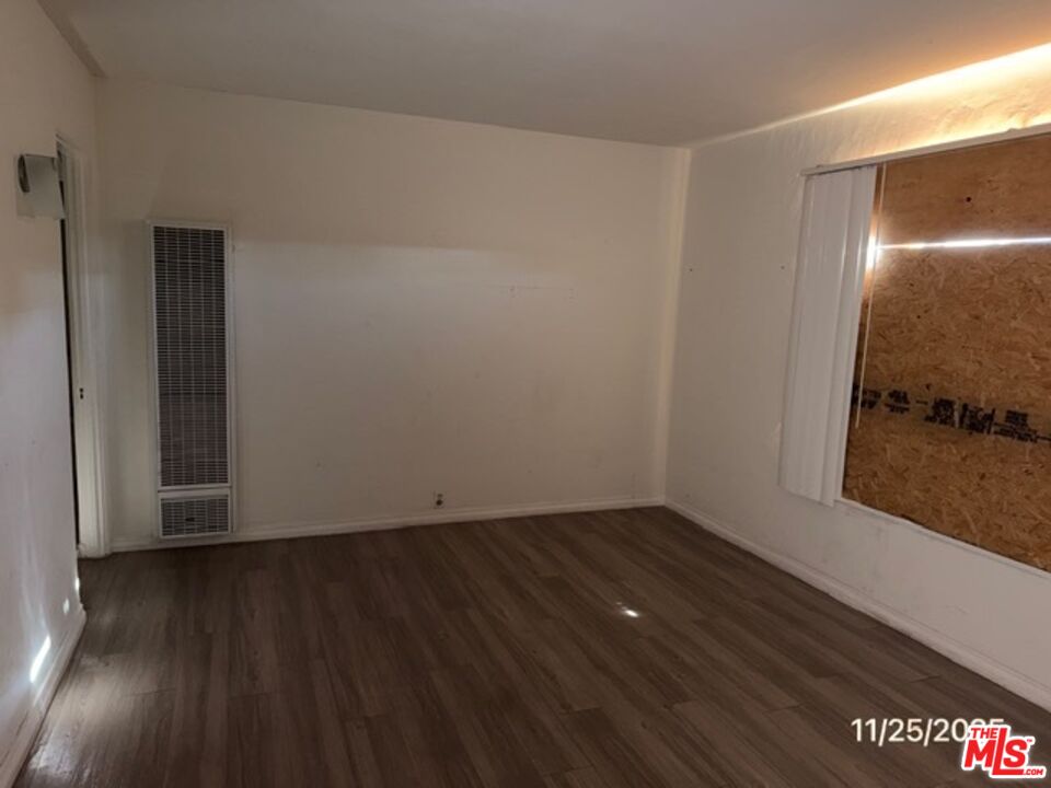 1740 South Rimpau Boulevard Los Angeles, CA 90019 - Photo 16 of 18 an empty room with wooden floor and windows