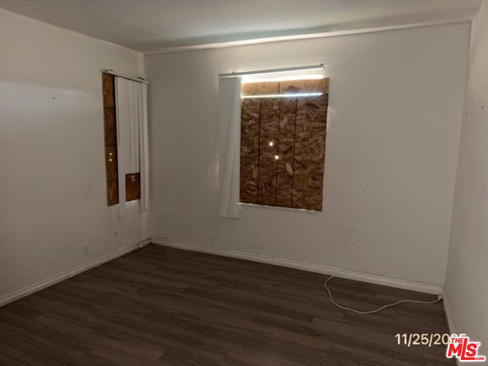 1740 South Rimpau Boulevard Los Angeles, CA 90019 - Photo 18 of 18 a view of an empty room with wooden floor and a window