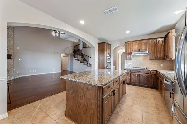 a kitchen with stainless steel appliances granite countertop a sink stove and cabinets