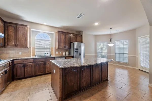 a kitchen with stainless steel appliances granite countertop a sink counter space cabinets and a large window
