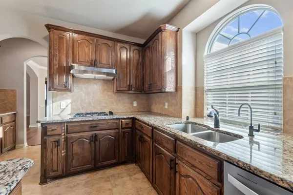 a kitchen with stainless steel appliances granite countertop a sink stove and cabinets