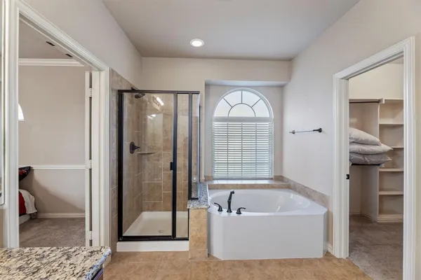 a bathroom with a tub a sink and a shower