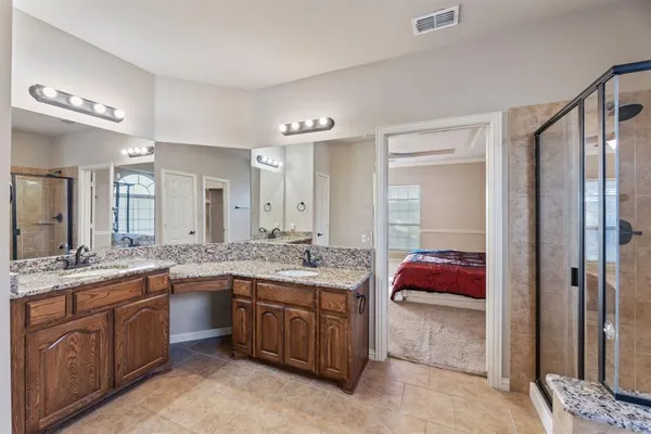 a en suite bathroom with a granite countertop sink and a mirror