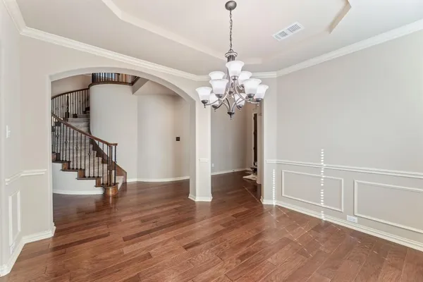 a view of a livingroom with wooden floor and staircase