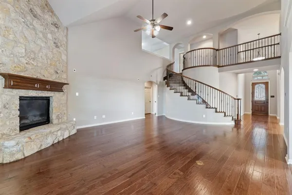 a view of a hallway with wooden floor staircase and a kitchen