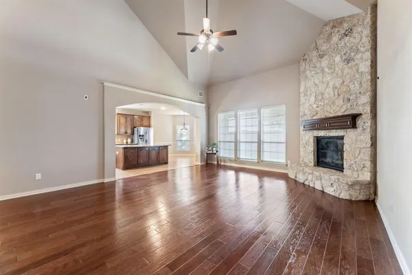 a view of a livingroom with wooden floor a fireplace and windows