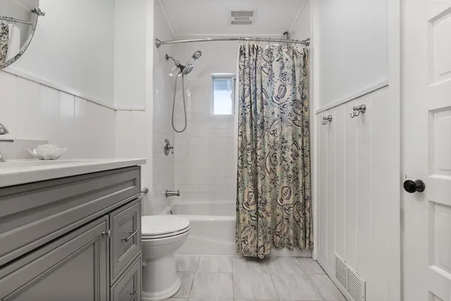 a bathroom with a shower a toilet and sink