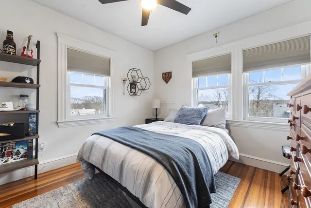 a bedroom with a bed and a window with chair