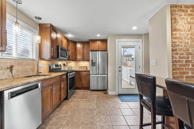 a kitchen with stainless steel appliances granite countertop a refrigerator stove top oven and sink
