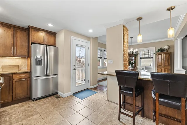 a kitchen with stainless steel appliances kitchen island granite countertop a refrigerator and a stove top oven