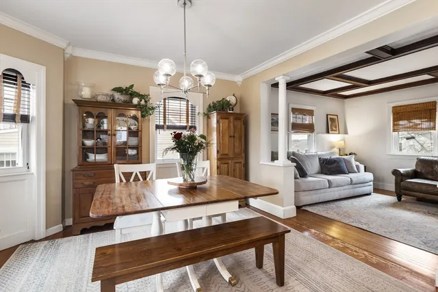 a living room with dining table and a chandelier