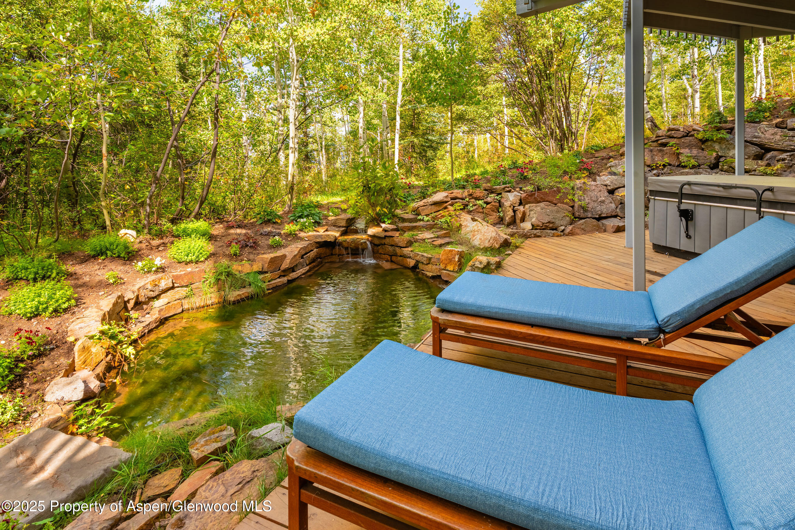 239 Antler Ridge Lane Snowmass Village, CO 81615 - Photo 36 of 50 a blue swimming pool with lawn chairs next to a yard