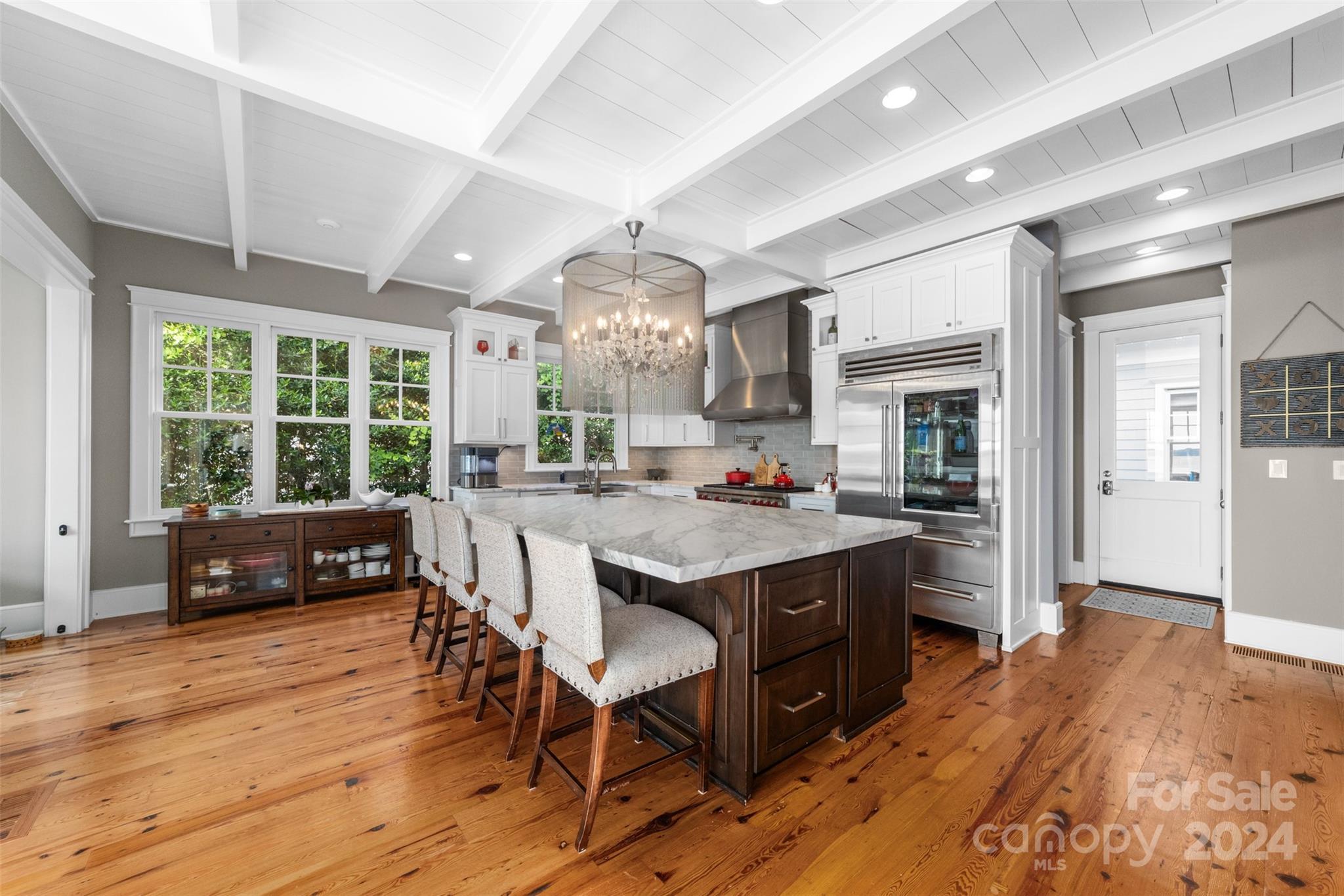 15515 Jetton Road Cornelius, NC 28031 - Photo 16 of 48 a kitchen with stainless steel appliances granite countertop a stove a refrigerator a sink dishwasher a dining table and chairs with wooden floor