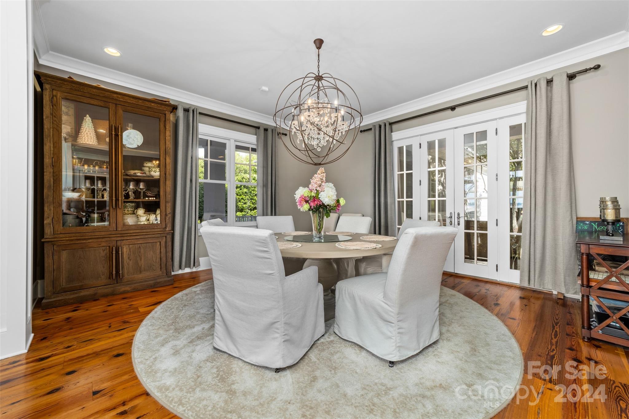 15515 Jetton Road Cornelius, NC 28031 - Photo 20 of 48 a dining room with wooden floor a chandelier a wooden table and chairs