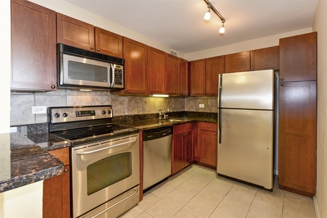655 West Irving Park Road, Unit 5311 Chicago, IL 60613 - Photo 5 of 10 a kitchen with stainless steel appliances granite countertop a refrigerator stove and microwave