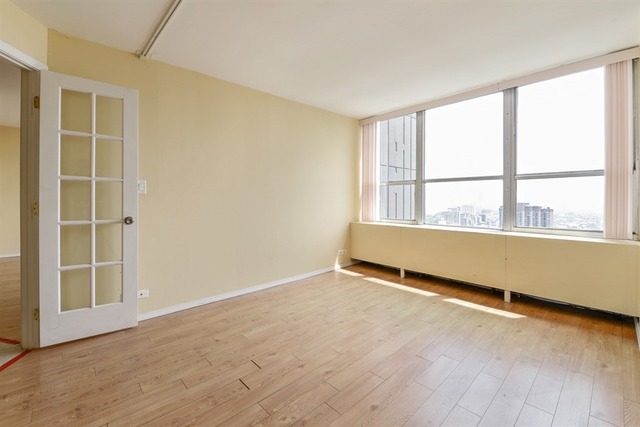 655 West Irving Park Road, Unit 5311 Chicago, IL 60613 - Photo 7 of 10 an empty room with wooden floor and windows