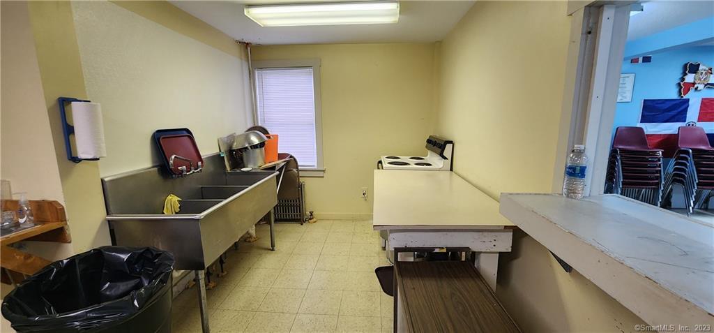 60 Jay Street New London, CT 06320 - Photo 6 of 17 a room with table chairs and a stove