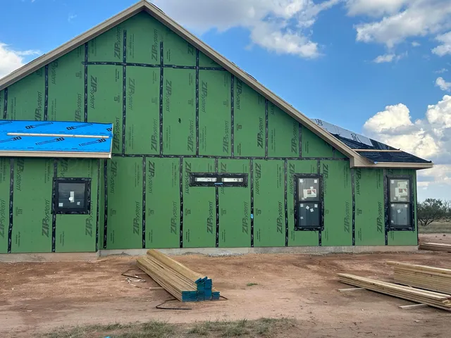a view of a house with a patio and a yard