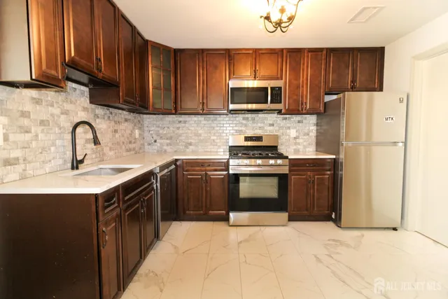 a kitchen with stainless steel appliances granite countertop a refrigerator stove a sink dishwasher and microwave with cabinets