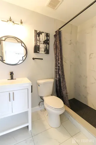 a bathroom with a sink mirror vanity and toilet