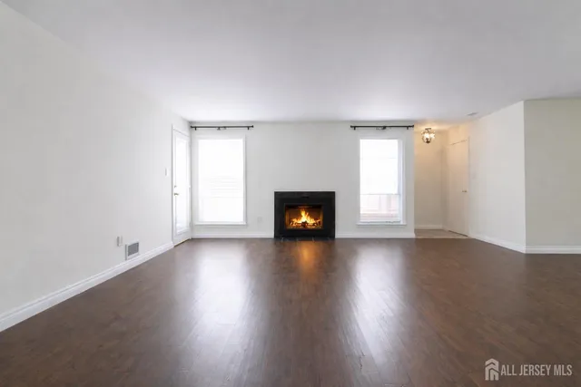 an empty room with wooden floor and fireplace