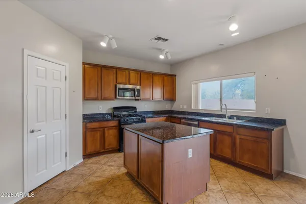 a kitchen with stainless steel appliances granite countertop hardwood a sink stove and refrigerator