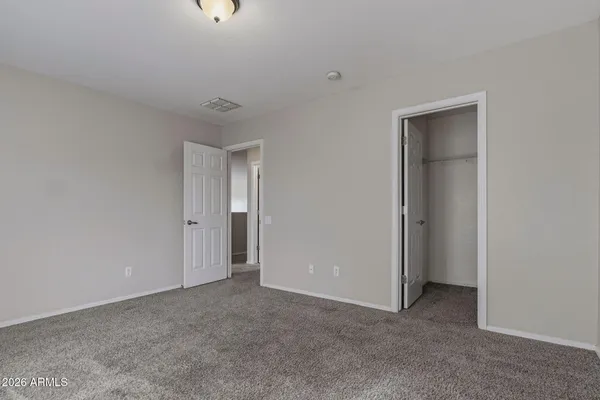 a view of an empty room with closet and windows