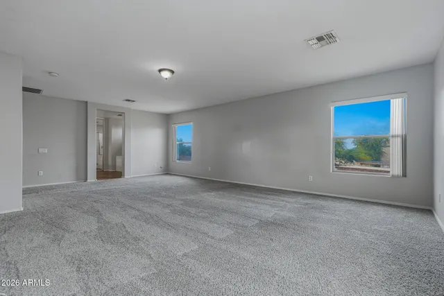 a view of an empty room with window and closet area