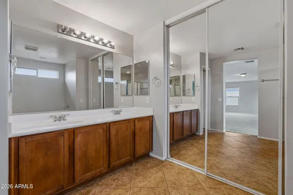 a spacious bathroom with a mirror a double vanity sink and glass door