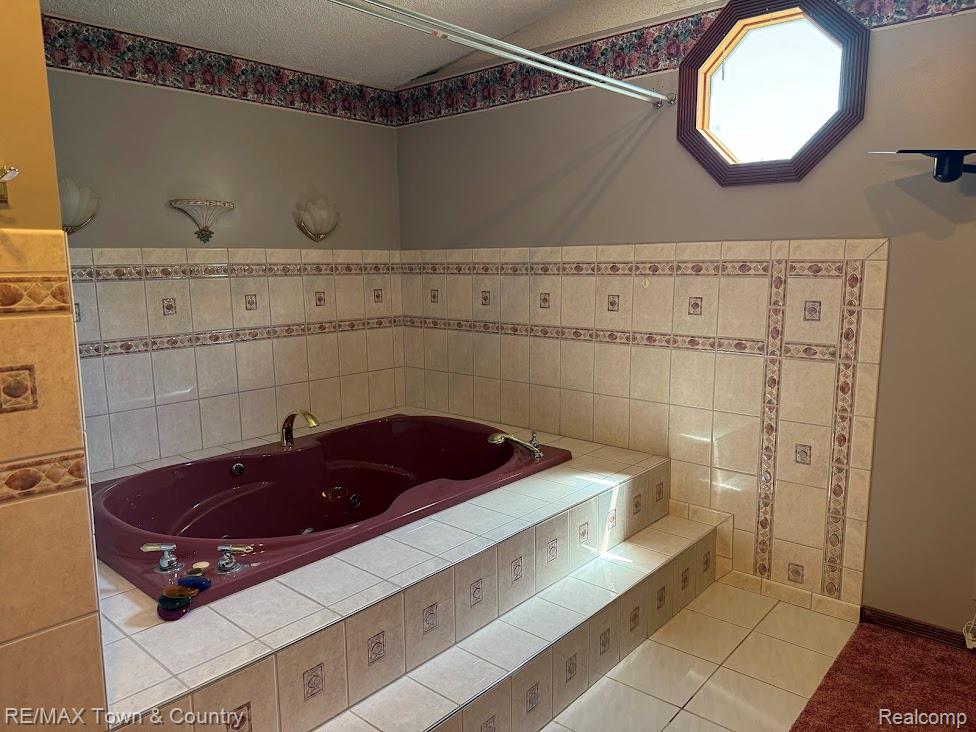 4372 North Gale Road Davison, MI 48423 - Photo 21 of 46 Built-in soaking tub with steps, ceramic tile surround, and an octagonal window