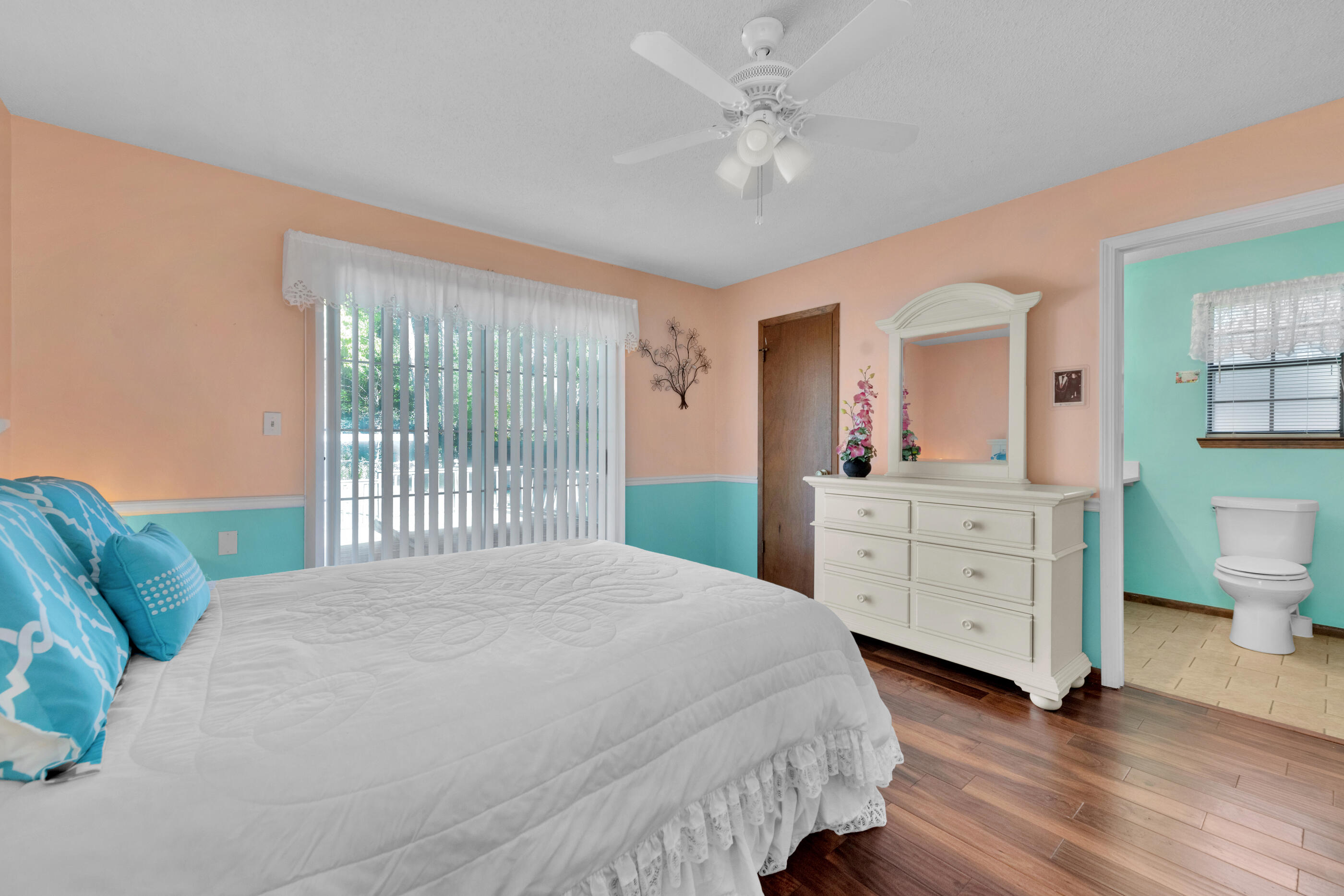 371 Echo Circle Fort Walton Beach, FL 32548 - Photo 16 of 36 a bedroom with a bed a chandelier and a window