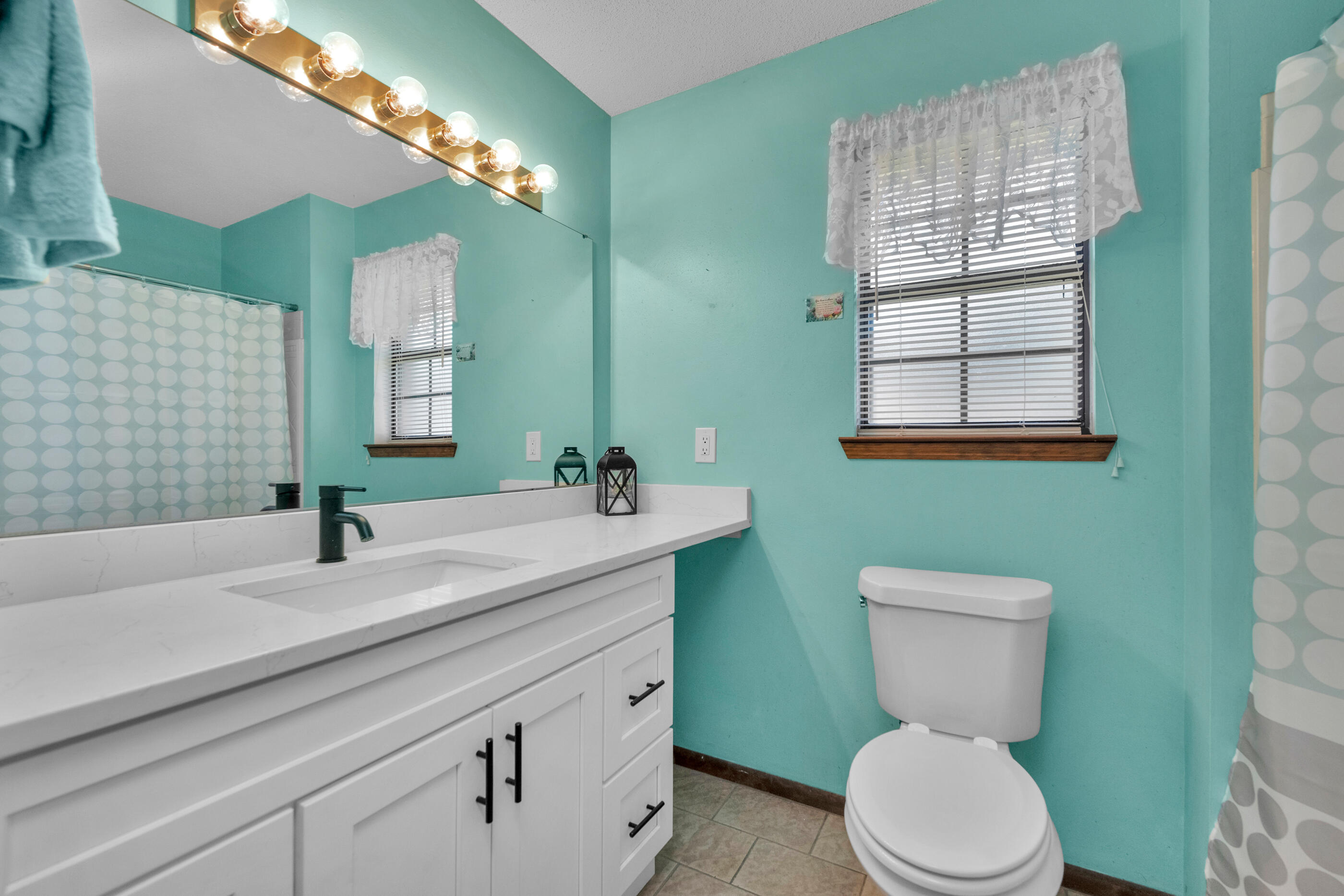 371 Echo Circle Fort Walton Beach, FL 32548 - Photo 18 of 36 a bathroom with a sink a toilet and mirror