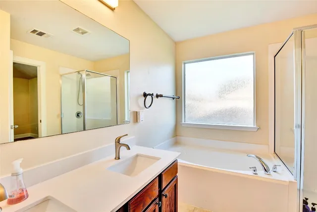 a bathroom with a tub sink and mirror