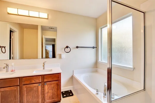 a bathroom with a tub sink and mirror