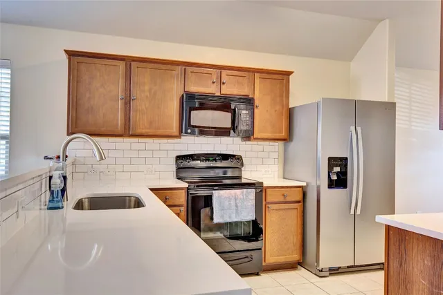 a kitchen with stainless steel appliances a stove microwave and refrigerator