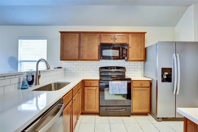 a kitchen with stainless steel appliances granite countertop a sink and a refrigerator