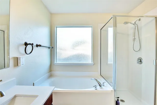 a bathroom with a bath tub with a shower