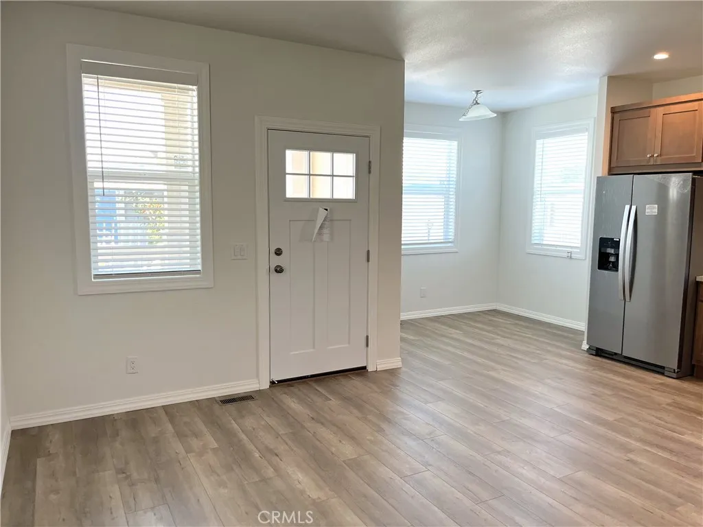 301 East Foothill Boulevard, Unit 59 Pomona, CA 91767 - Photo 4 of 9 a view of an empty room with wooden floor and a window
