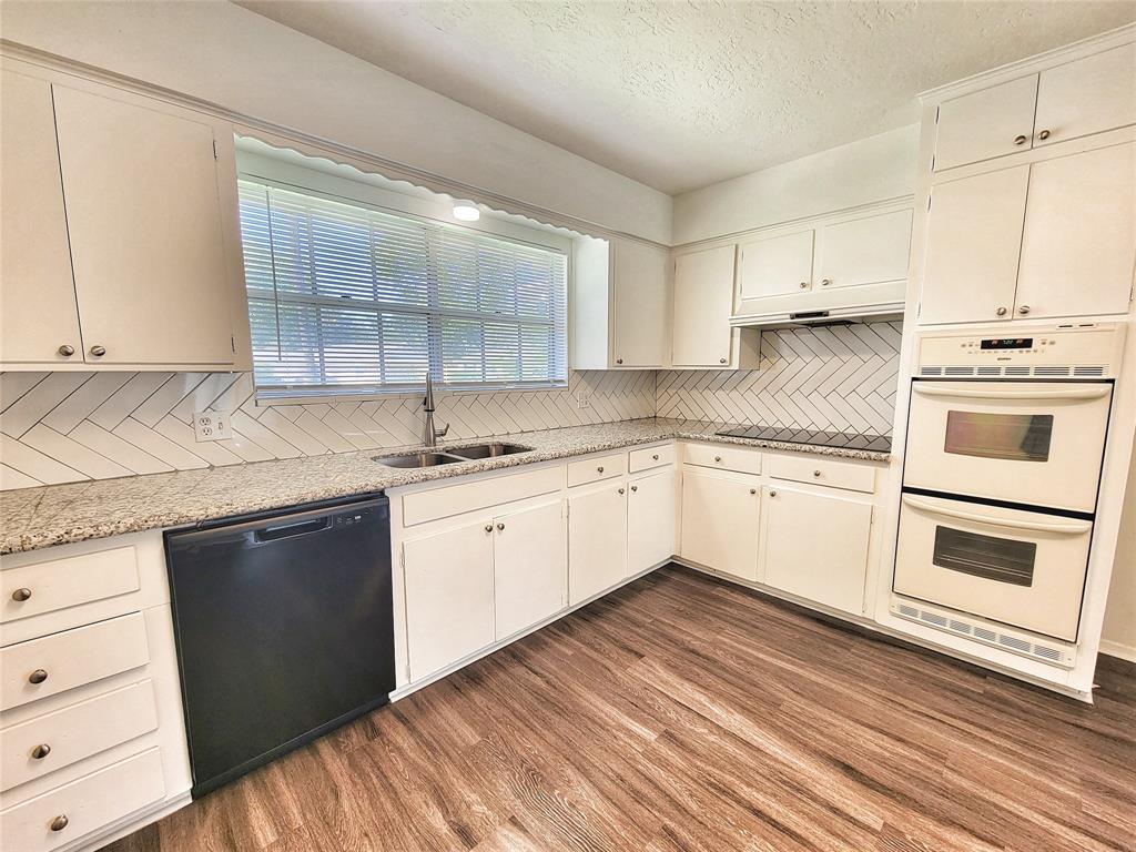 a white kitchen with granite countertop white cabinets and white appliances