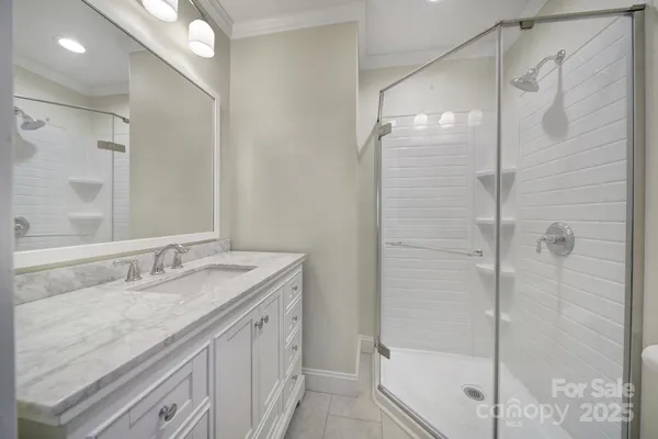 a bathroom with a granite countertop shower sink and mirror