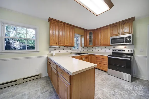 a kitchen with kitchen island granite countertop a sink stove and refrigerator