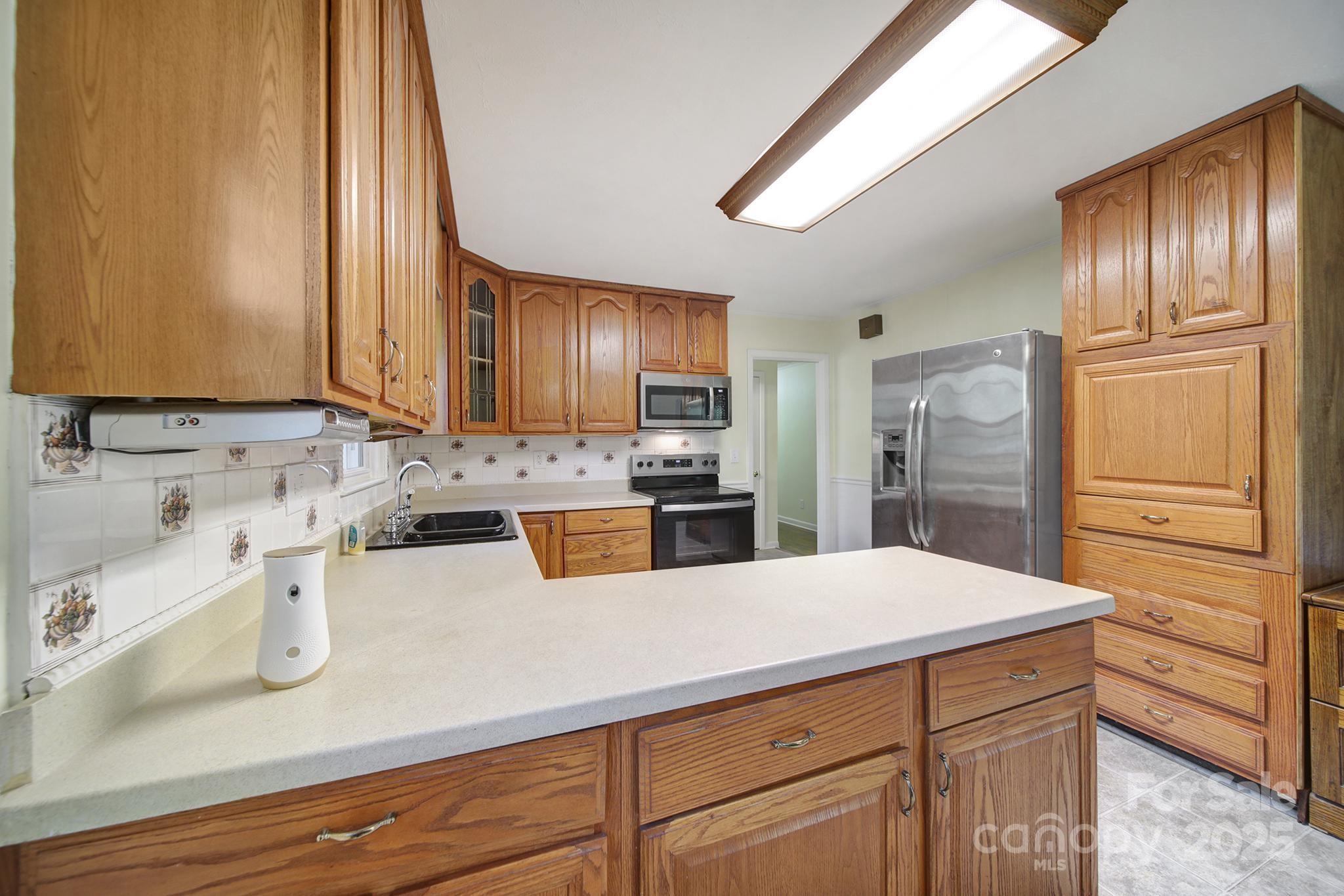 3987 Taxahaw Road Lancaster, SC 29720 - Photo 16 of 29 a kitchen with stainless steel appliances a refrigerator sink and cabinets