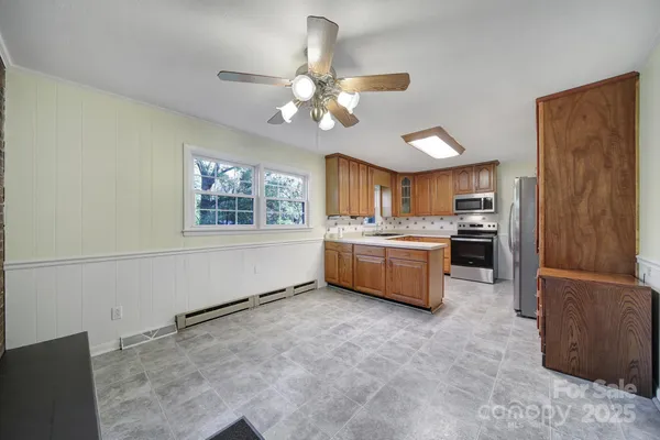 a kitchen with a stove a refrigerator and chandelier