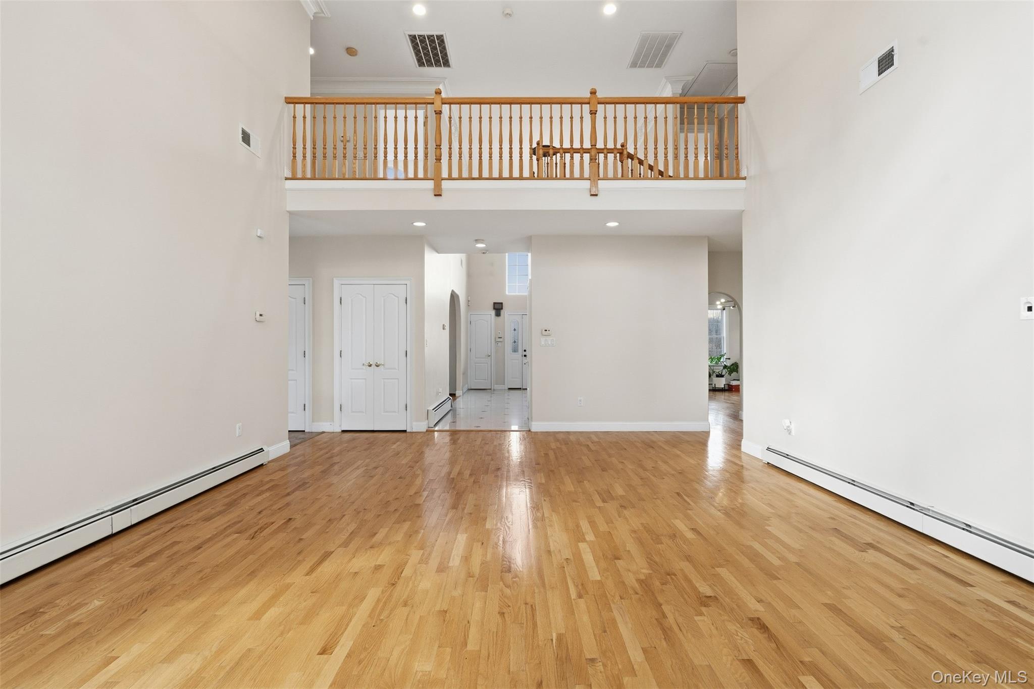 54 Pyngyp Road Stony Point, NY 10980 - Photo 11 of 28 Unfurnished living room featuring arched walkways, a high ceiling, recessed lighting, light wood-style flooring, and baseboard heating