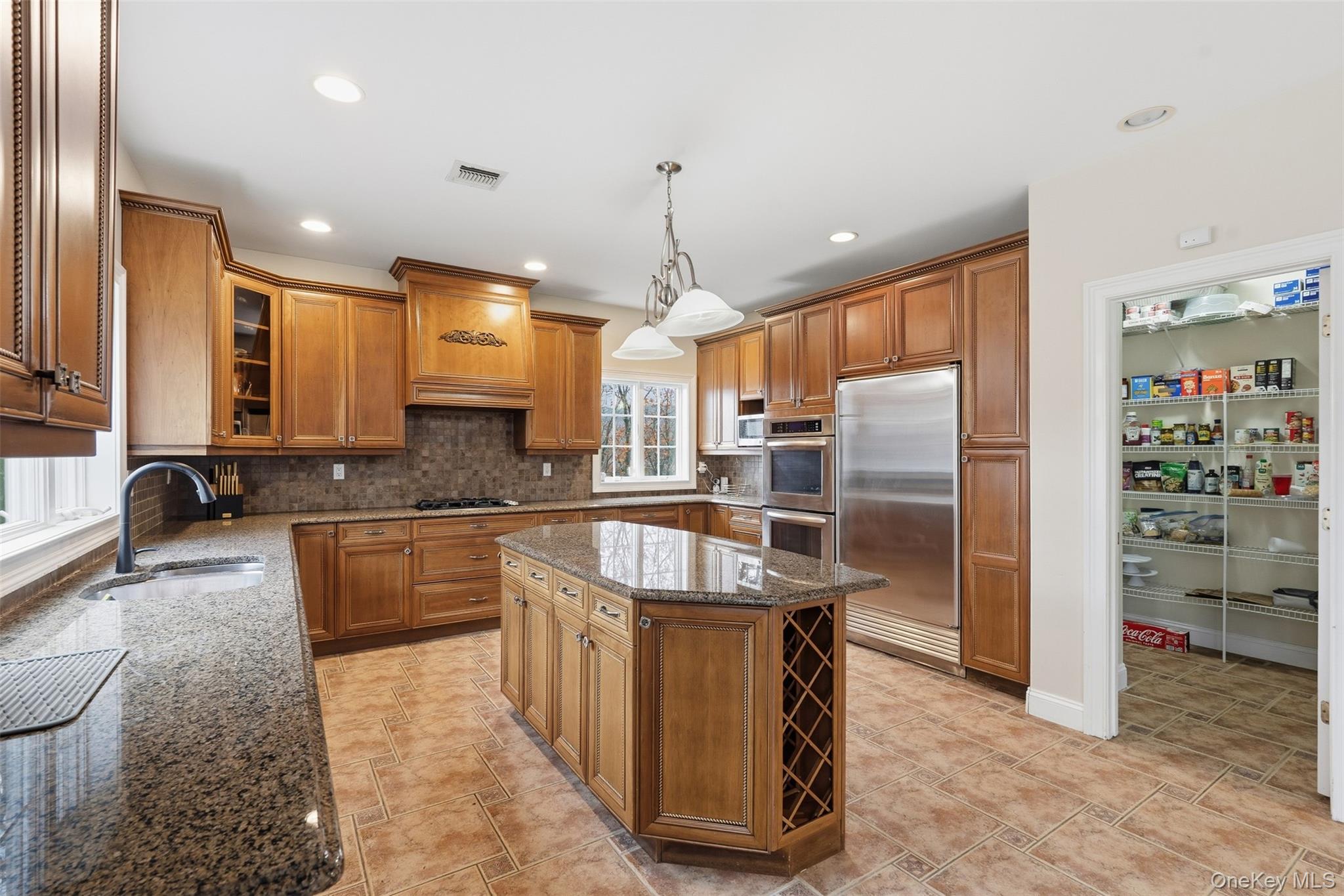 54 Pyngyp Road Stony Point, NY 10980 - Photo 18 of 28 Kitchen with dark stone countertops, brown cabinetry, backsplash, stainless steel appliances, and glass insert cabinets