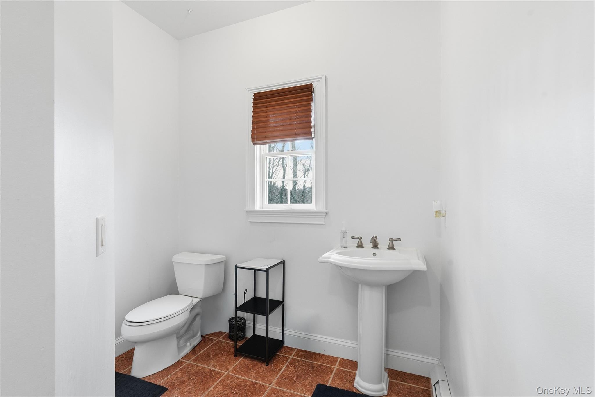 54 Pyngyp Road Stony Point, NY 10980 - Photo 19 of 28 Half bath featuring dark tile patterned floors and a baseboard radiator