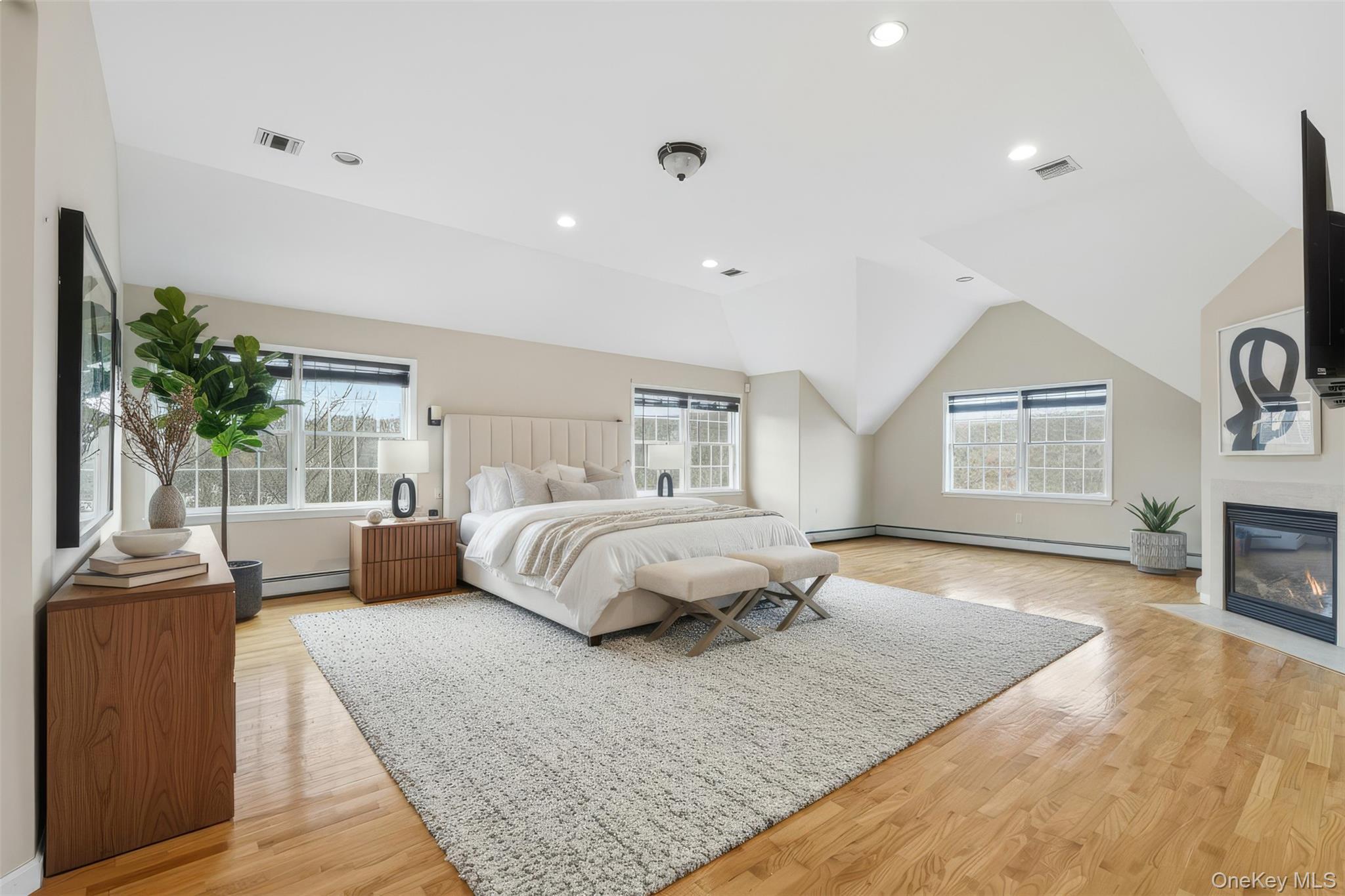 54 Pyngyp Road Stony Point, NY 10980 - Photo 22 of 28 Bedroom with light wood-type flooring, recessed lighting, multiple windows, a fireplace with flush hearth, and vaulted ceiling