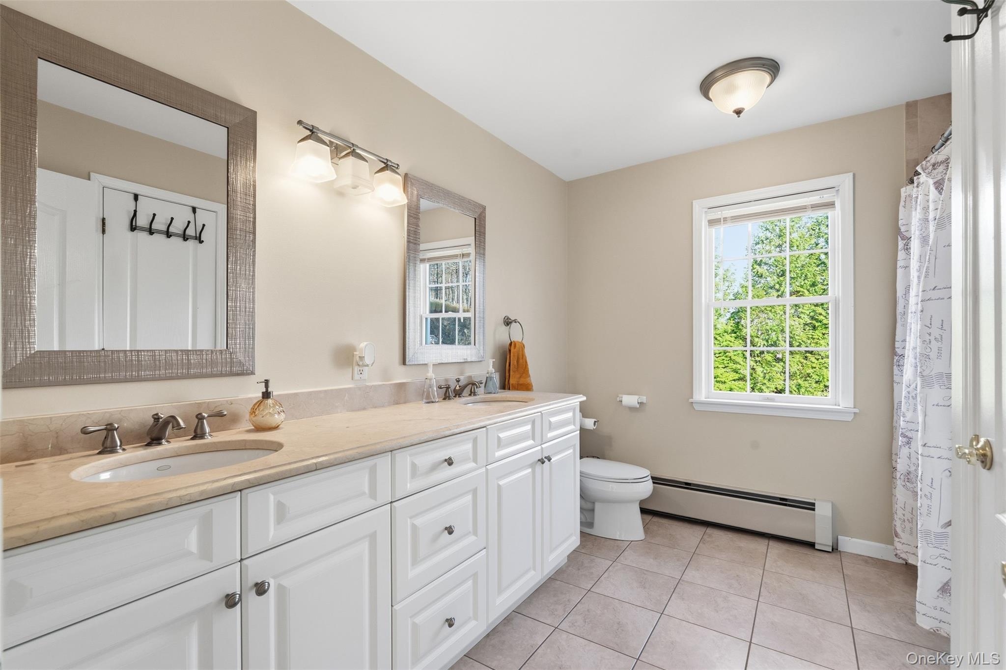 54 Pyngyp Road Stony Point, NY 10980 - Photo 26 of 28 Full bathroom featuring a baseboard radiator, double vanity, light tile patterned flooring, and a shower with shower curtain