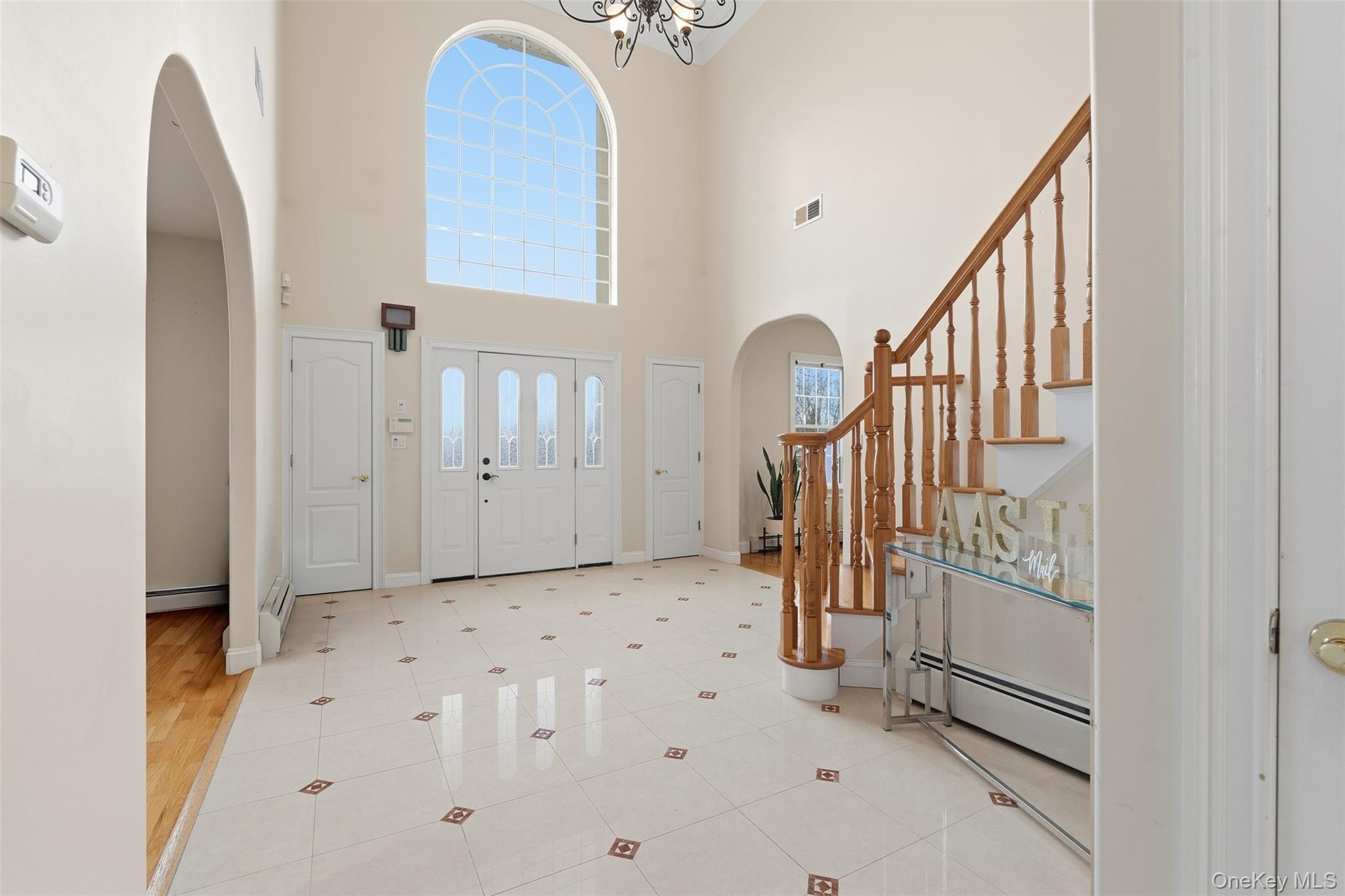 54 Pyngyp Road Stony Point, NY 10980 - Photo 6 of 28 Foyer entrance with arched walkways, stairway, light tile patterned flooring, a baseboard heating unit, and a high ceiling
