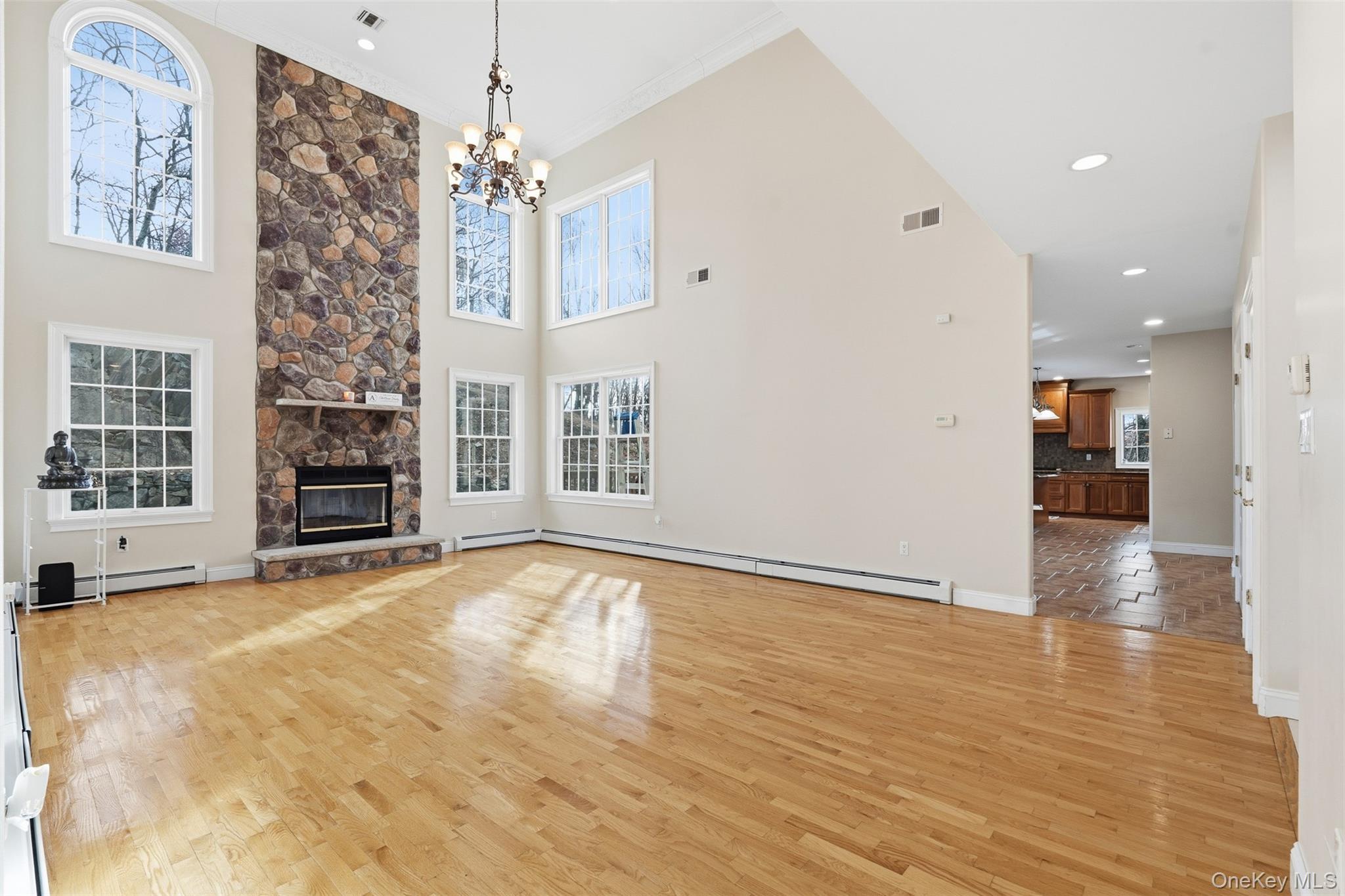 54 Pyngyp Road Stony Point, NY 10980 - Photo 10 of 28 Unfurnished living room featuring light wood-type flooring, a fireplace, recessed lighting, a chandelier, and baseboard heating